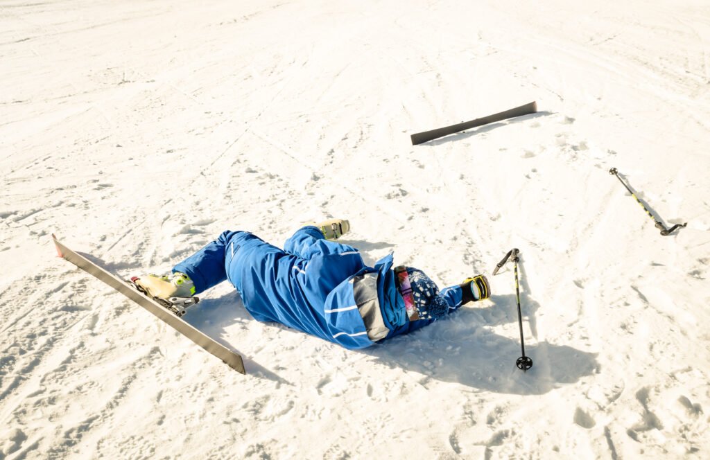 Sciatore a terra sulla pista dopo una caduta